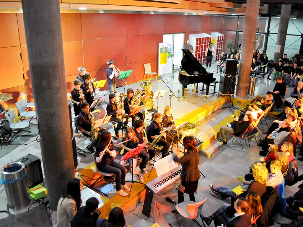 Orchester spielt vor der roten Wand.